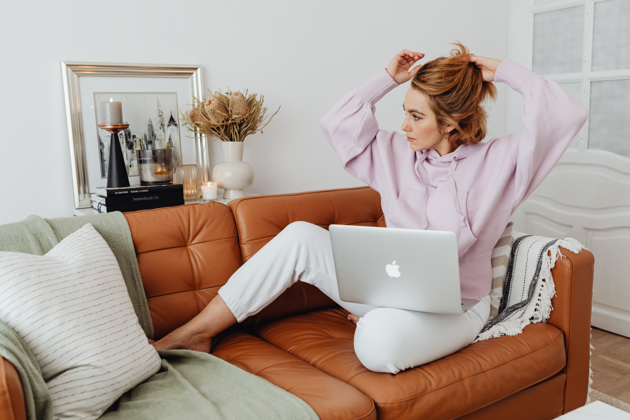 kobieta pracuje z laptopem na kanapie - jak pracować zdalnie, jak zorganizować sobie pracę